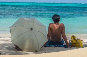 Ambergris Caye woman on the beach with an umbrella – Best Places In The World To Retire – International Living